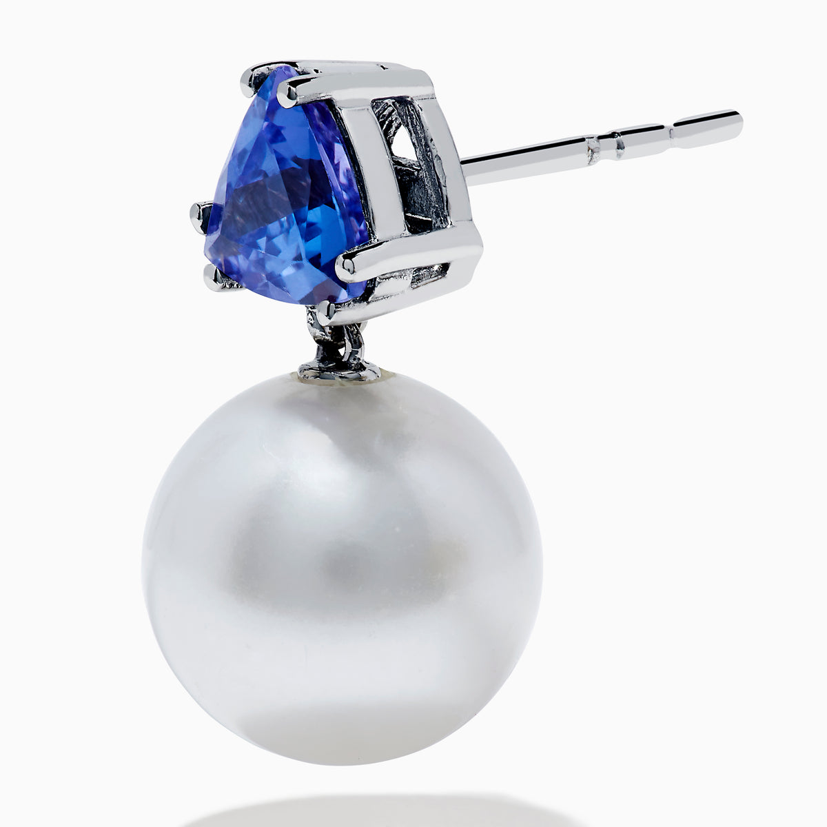 The Nahla 14K White Gold Fresh Water Pearl and Tanzanite Earrings feature round white pearls suspended below triangular blue tanzanite gemstones, set in white gold, displayed on a white background.