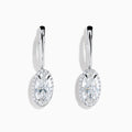 The Lab Grown Diamond Elongated Oval Drop Earrings in 14K White Gold feature clear gemstones surrounded by lab grown diamonds, set in polished white gold with a simple hook design, displayed against a white background.