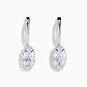 The Lab Grown Diamond Elongated Oval Drop Earrings in 14K White Gold feature clear gemstones surrounded by lab grown diamonds, set in polished white gold with a simple hook design, displayed against a white background.