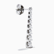 The 925 Sterling Silver Diamond Linear Drop Earrings showcase a vertical row of round, graduated diamonds that increase in size towards the bottom.