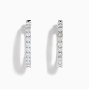 A stunning pair of 14K White Gold Diamond Inside Out 1" Hoop Earrings, each adorned with a row of brilliant round white diamonds, displayed vertically against a white background with soft shadows. These hoop earrings are designed in an inside out style, ensuring each diamond sparkles beautifully from every angle.