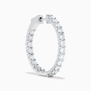 A stunning pair of 14K White Gold Diamond Inside Out 1" Hoop Earrings, each adorned with a row of brilliant round white diamonds, displayed vertically against a white background with soft shadows. These hoop earrings are designed in an inside out style, ensuring each diamond sparkles beautifully from every angle.