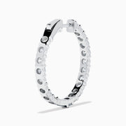 A stunning pair of 14K White Gold Diamond Inside Out 1" Hoop Earrings, each adorned with a row of brilliant round white diamonds, displayed vertically against a white background with soft shadows. These hoop earrings are designed in an inside out style, ensuring each diamond sparkles beautifully from every angle.