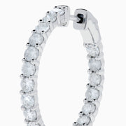 A stunning pair of 14K White Gold Diamond Inside Out 1" Hoop Earrings, each adorned with a row of brilliant round white diamonds, displayed vertically against a white background with soft shadows. These hoop earrings are designed in an inside out style, ensuring each diamond sparkles beautifully from every angle.