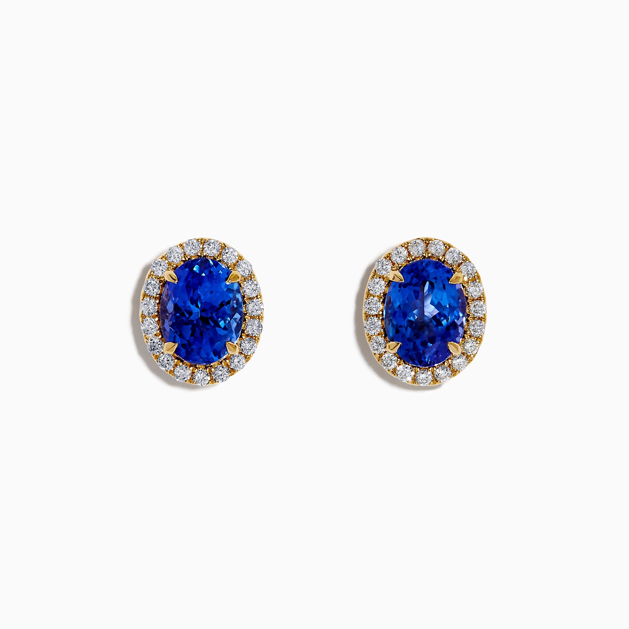 The Nahla 14K Yellow Gold Tanzanite and Diamond Stud Earrings feature oval blue tanzanites each encircled by a halo of diamonds, beautifully displayed on a white background.