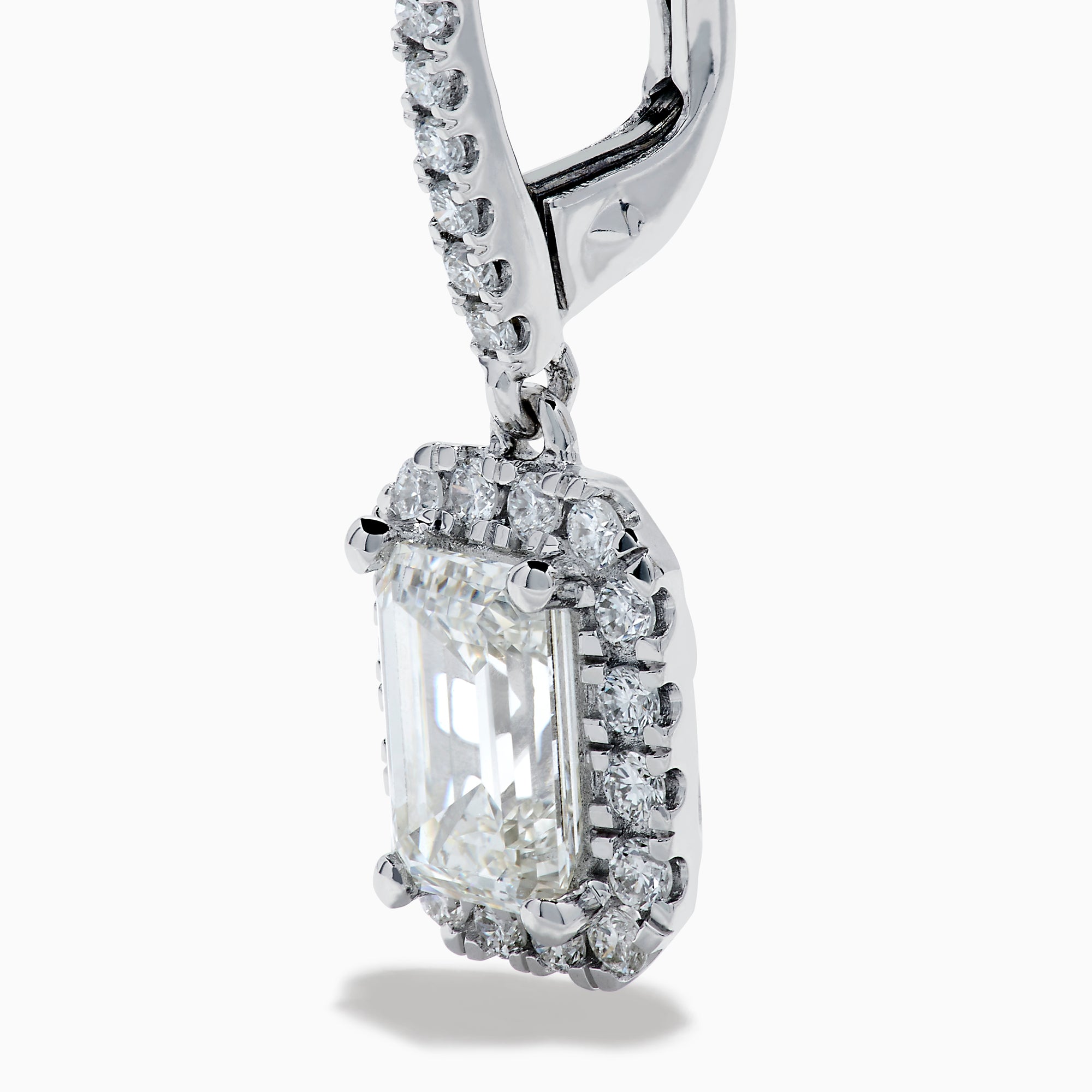 The Lab Grown Diamond Emerald Cut Dangle Earrings in 14K White Gold showcase emerald cut lab grown centers with a halo of round diamonds and diamond-encrusted hooks, elegantly presented against a white background.
