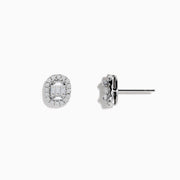 The Classique 14K White Gold Diamond Stud Earrings 0.59 TCW feature oval studs with central baguette-cut diamonds, each encircled by a halo of sparkling round stones.