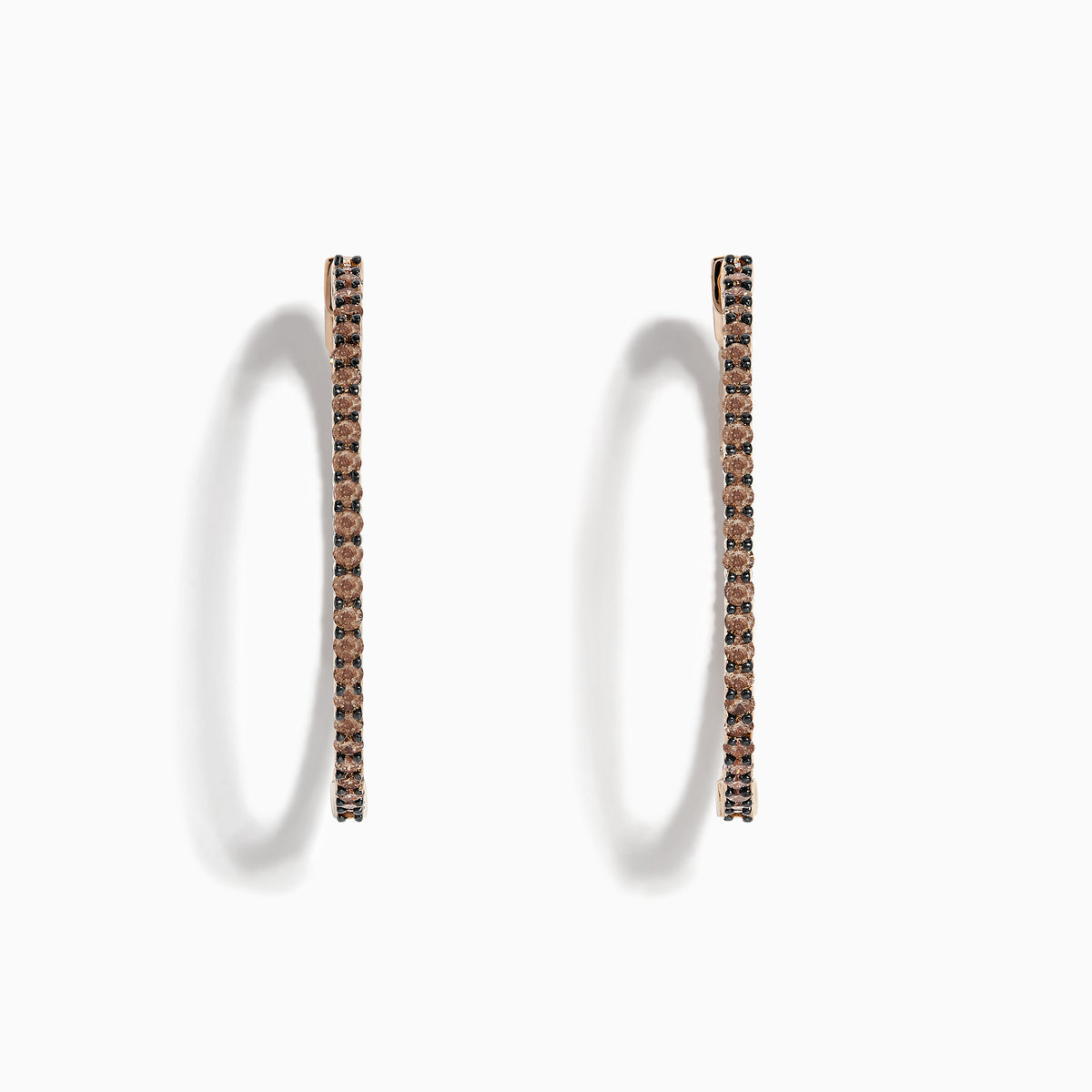 The 14K Rose Gold Brown Diamond 1.5 Inch Hoop Earrings, featuring slim vertical hoops with dark brown diamonds, are photographed against a plain white background, casting soft oval-shaped shadows to the left.