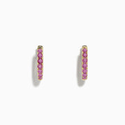 A pair of 14k Yellow Gold Pink Sapphire Huggie Earrings displayed against a plain white background.