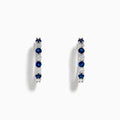 The 14K White Gold Sapphire and Diamond Hoop Earrings feature alternating round sapphires and diamonds, beautifully set and displayed on a white background.