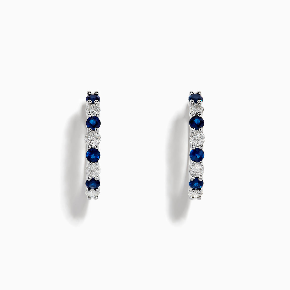 The 14K White Gold Sapphire and Diamond Hoop Earrings feature alternating round sapphires and diamonds, beautifully set and displayed on a white background.