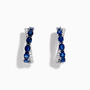 The Royale Bleu 14K White Gold Blue Sapphire and Diamond Hoop Earrings feature alternating oval blue sapphires and sparkling diamonds, all set in a white gold band and displayed against a white background.