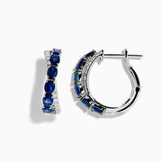 The Royale Bleu 14K White Gold Blue Sapphire and Diamond Hoop Earrings feature alternating oval blue sapphires and sparkling diamonds, all set in a white gold band and displayed against a white background.