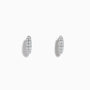 The Pave Classica 14k White Gold Diamond Huggie Earrings showcase elegant white gold design with sparkling diamonds, beautifully displayed against a plain white background.