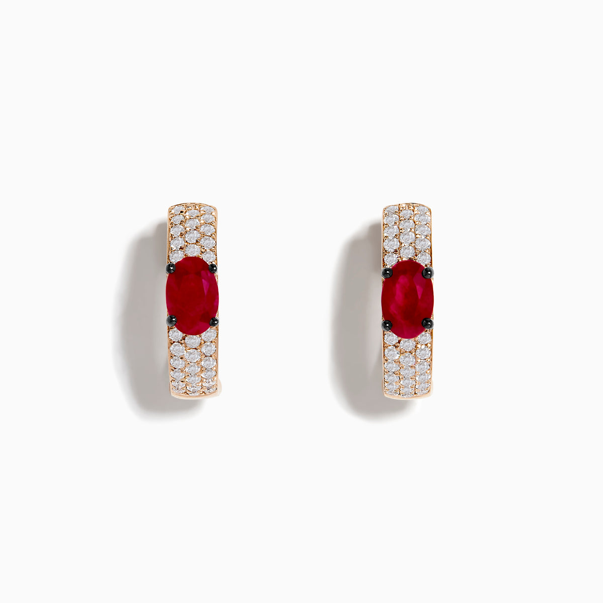 These 14K Rose Gold Ruby and Diamond Huggie Hoop Earrings feature a central oval ruby surrounded by rows of sparkling diamonds, creating a stunning shine against any background.
