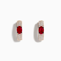 These 14K Rose Gold Ruby and Diamond Huggie Hoop Earrings feature a central oval ruby surrounded by rows of sparkling diamonds, creating a stunning shine against any background.