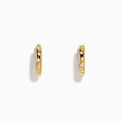 The D'Oro 14K Yellow Gold Diamond Huggie Earrings each feature three round white diamonds set vertically and are displayed against a plain white background.
