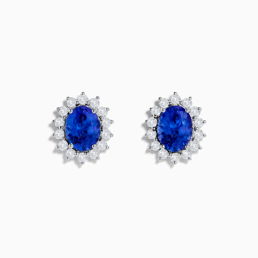 The Nahla Siri 14K White Gold Tanzanite and Diamond Earrings feature oval tanzanite stones surrounded by a halo of sparkling diamonds, elegantly set in white gold and displayed on a white background.