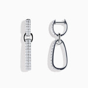 The Pave 14K White Gold Diamond Interlocking Hoop Earrings include one straight, diamond-encrusted bar and one open, asymmetrical, diamond-lined hoop, creating a modern mismatched look against a white background.