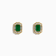 The 14K Yellow Gold Emerald and Diamond Halo Stud Earrings showcase rectangular green gemstones encircled by round and baguette-cut diamonds, displayed on a plain white background.