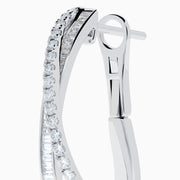 A pair of 14K White Gold Diamond Crossover Hoop Earrings featuring two intertwined, diamond-encrusted lines on each hoop, displayed against a plain white background.