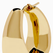 The 14K Yellow Gold High-Polish Tapered Wide Hoop Earrings feature a sleek, modern design with a sculptural, high-shine finish, shown against a plain white background.