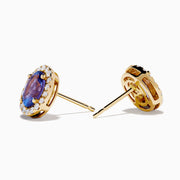The Nahla 14K Yellow Gold Tanzanite and Diamond Stud Earrings feature oval blue tanzanites haloed by small diamonds, set in yellow gold and shown on a white background.