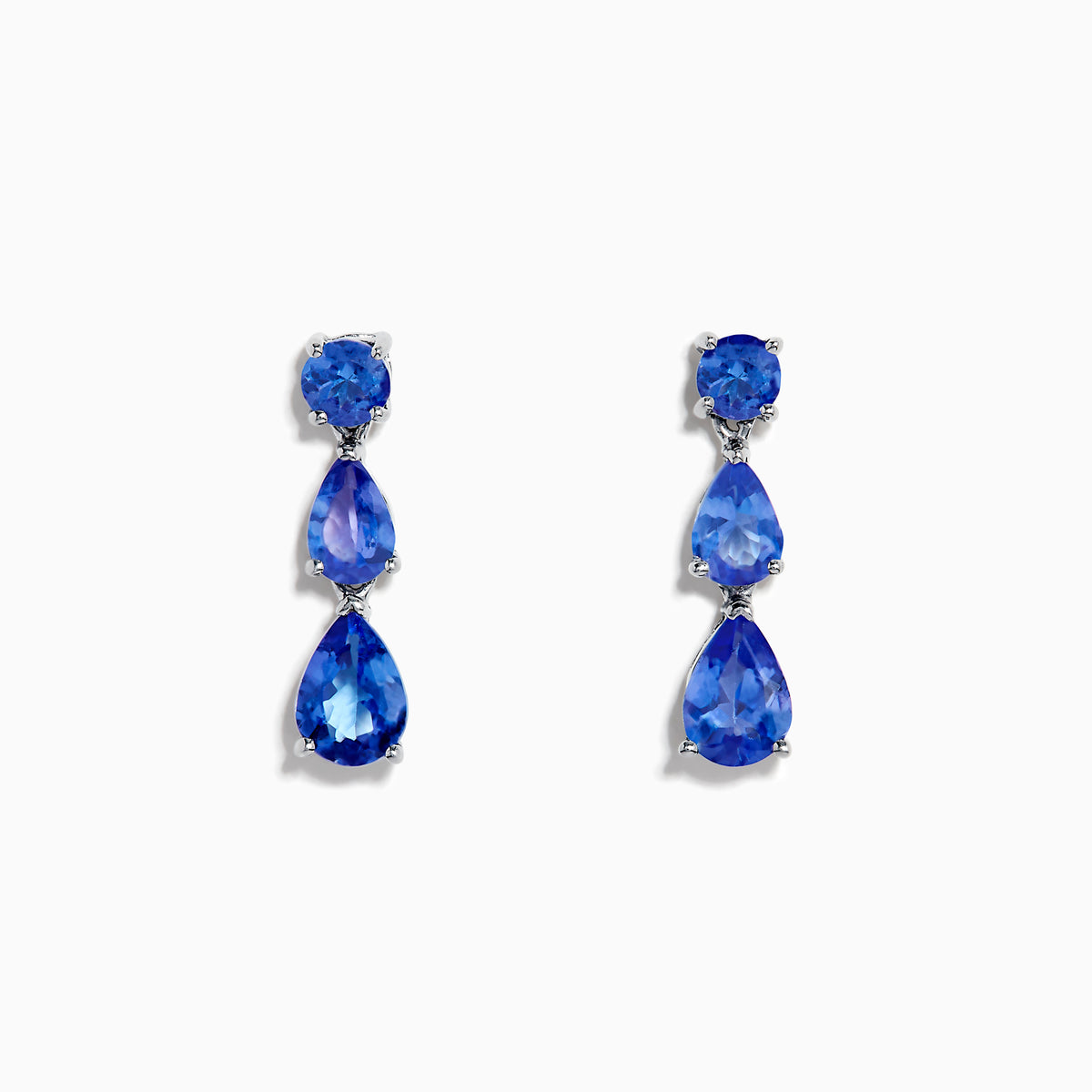 The Nahla Siri 925 Silver Tanzanite Drop Earrings feature three blue gemstones—one round and two teardrop-shaped—in varying blue shades, set against a white background.