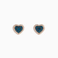 The Bella Bleu 14K Rose Gold Blue and White Diamond Heart Earrings showcase blue and white diamonds at the center, bordered by clear stones in a rose gold setting, displayed against a white background.