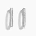 The Pave Classica 14 Karat White Gold Diamond 1.25 Hoop Earrings feature sparkling white diamonds totaling 2.24 TCW, set in elegant oval-shaped hoops and shown against a plain white background.