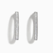 The Pave Classica 14 Karat White Gold Diamond 1.25 Hoop Earrings feature sparkling white diamonds totaling 2.24 TCW, set in elegant oval-shaped hoops and shown against a plain white background.