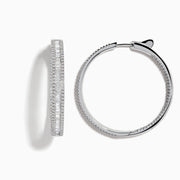 The Pave Classica 14 Karat White Gold Diamond 1.25 Hoop Earrings feature sparkling white diamonds totaling 2.24 TCW, set in elegant oval-shaped hoops and shown against a plain white background.