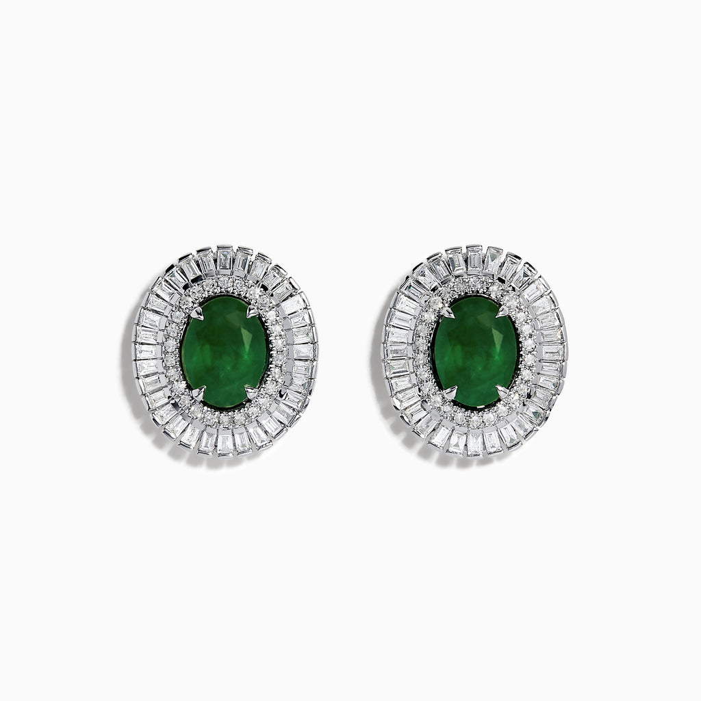 These 14K White Gold Emerald and Diamond Stud Earrings feature large oval emeralds at the center, accented by clear rectangular-cut diamonds for an elegant look.