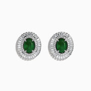 These 14K White Gold Emerald and Diamond Stud Earrings feature large oval emeralds at the center, accented by clear rectangular-cut diamonds for an elegant look.