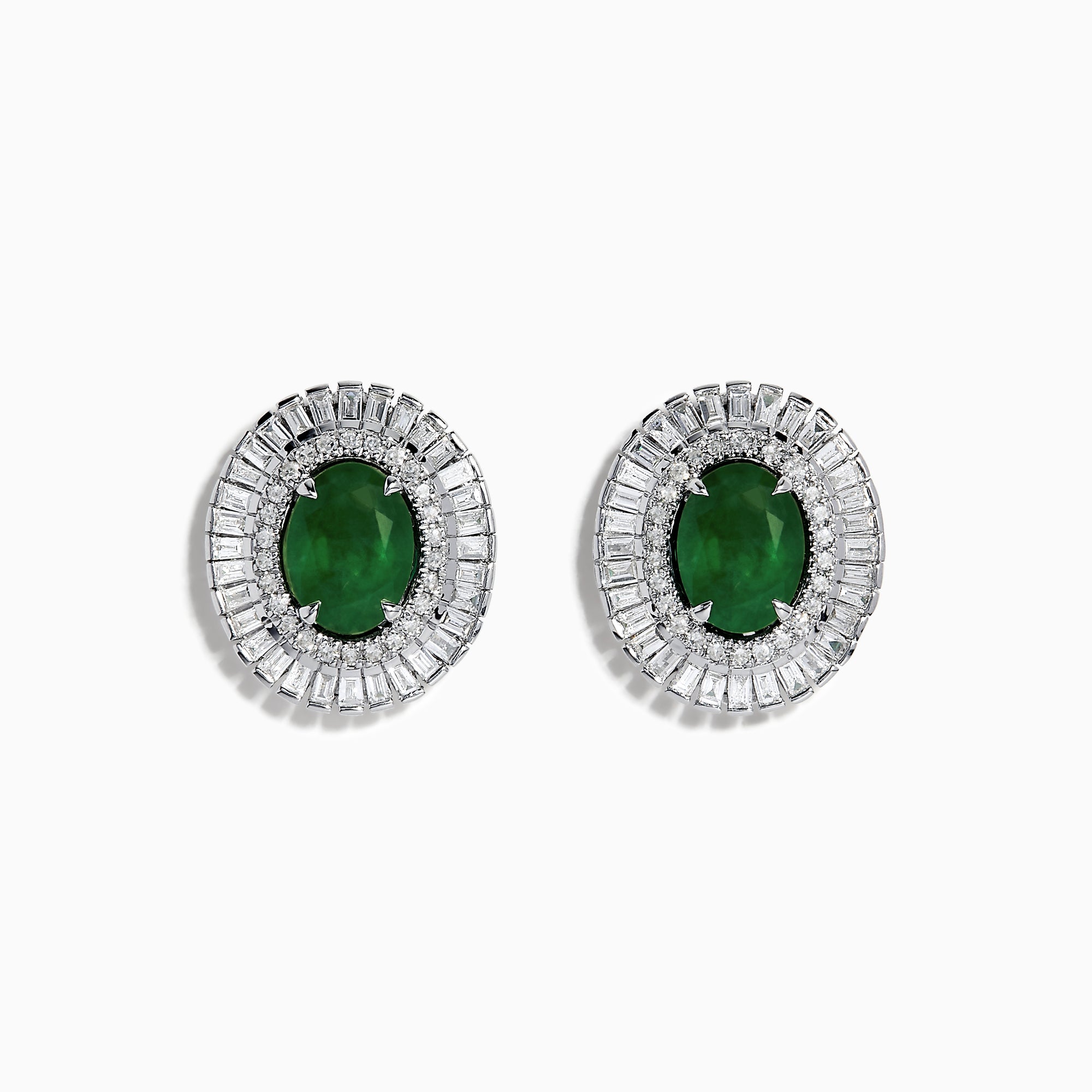 These 14K White Gold Emerald and Diamond Stud Earrings feature large oval emeralds at the center, accented by clear rectangular-cut diamonds for an elegant look.
