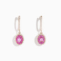 The 14K Rose Gold Pink Sapphire and Diamond Earrings feature oval pink sapphires encircled by diamonds, each suspended from a diamond-studded hook, displayed on a white background.