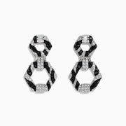 Showcased on a white background, these 14k White Gold Black and White Diamond Zebra Print Earrings feature alternating black and silver hexagonal segments encrusted with sparkling stones.
