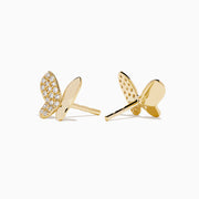 The Novelty 14K Yellow Gold Diamond Butterfly Stud Earrings feature one wing with sparkling diamonds and the other in polished gold, all crafted in 14K yellow gold and displayed on a plain white background.