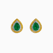 These 14K two tone gold emerald double halo earrings feature white and yellow diamonds in a teardrop design, elegantly displayed against a plain white background.