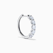 The Classique 14K White Gold Diamond Hoop Earrings feature five round diamonds on each hoop, shown against a white background for a timeless look.