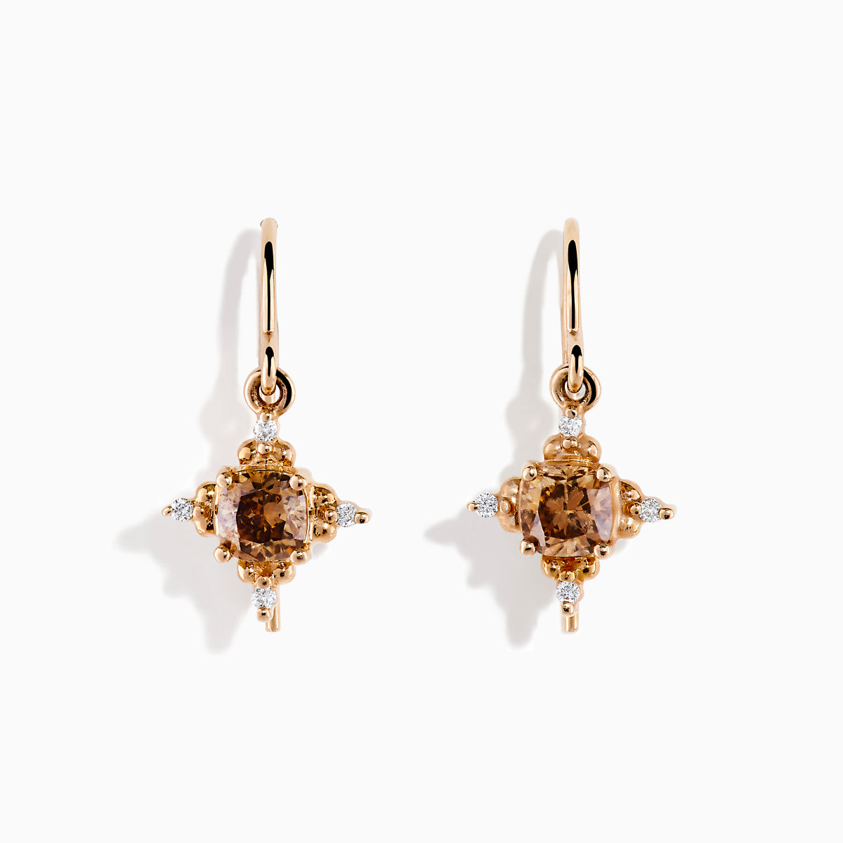 The 14K Rose Gold Brown and White Diamond Dangle Earrings feature a central brown diamond surrounded by white diamonds, each earring hanging from a simple rose gold hook.