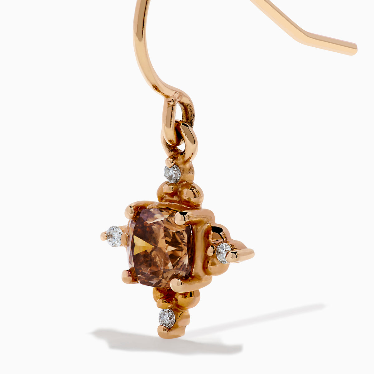 The 14K Rose Gold Brown and White Diamond Dangle Earrings feature a central brown diamond surrounded by white diamonds, each earring hanging from a simple rose gold hook.