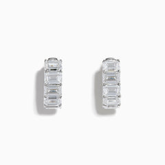 A pair of Lab Grown Emerald Cut Diamond Huggie Earrings in 14K white gold, each featuring three vertically-set rectangular clear stones, is displayed against a plain white background.