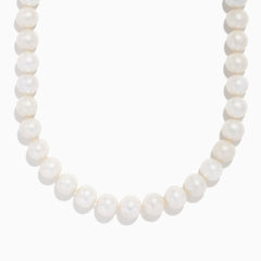 A close-up of the 14K Yellow Gold Fresh Water Pearl Necklace shows large, round freshwater pearls strung on 14K yellow gold, beautifully curved against a plain white background.