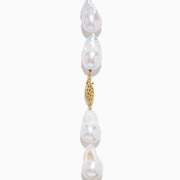 A close-up of the 14K Yellow Gold Freshwater Baroque Pearl Necklace featuring irregularly shaped white pearls and a 14K yellow gold clasp, set against a white background.