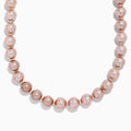 A close-up of the 14K Yellow Gold Freshwater Lilac Pearl Necklace highlights its round, glossy lilac pearls elegantly strung together in a gentle curve against a white background.