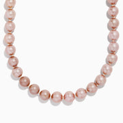 A close-up of the 14K Yellow Gold Freshwater Lilac Pearl Necklace highlights its round, glossy lilac pearls elegantly strung together in a gentle curve against a white background.