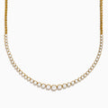 The 14K Yellow Gold Graduated Diamond Tennis Necklace showcases round diamonds set closely together, featuring larger center stones that gradually taper to smaller ones at the ends.