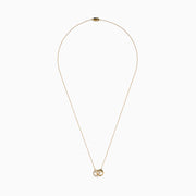 14K Yellow Gold Diamond Accented Interlocking Hearts Necklace featuring two entwined hearts—one with sparkling diamonds, the other polished smooth—shown on a plain white background.