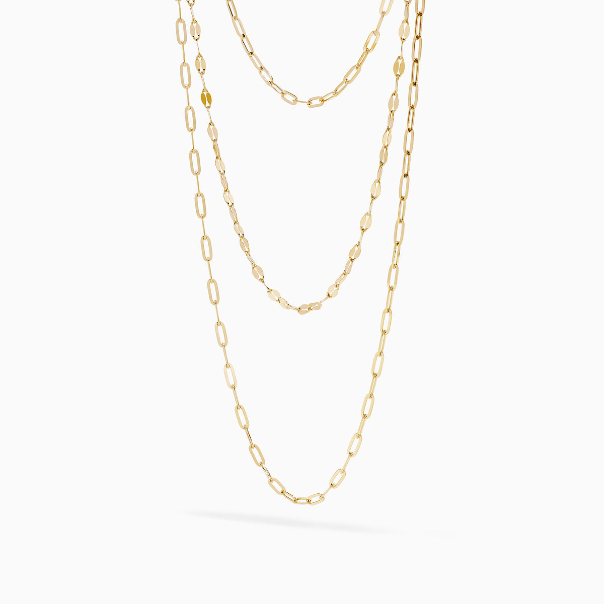 The 14K Yellow Gold Layered Chain Necklace features three delicate chains of different lengths with evenly spaced links, displayed on a white background—a perfect set for achieving effortless elegance.
